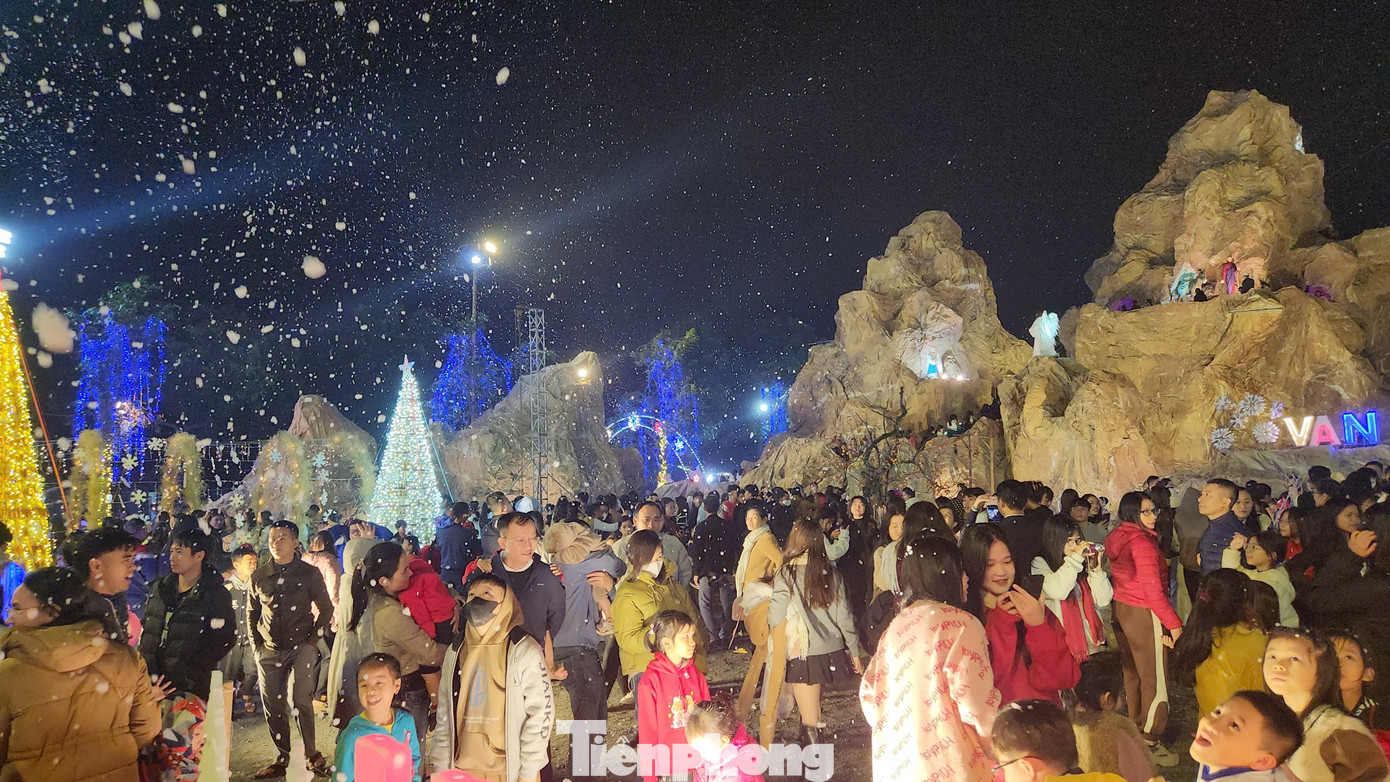 Bên ngoài hang đá được trang hoàng đèn nháy có nhiều màu sắc rực rỡ và máy phun tuyết nhân tạo khiến du khách rất thích thú.