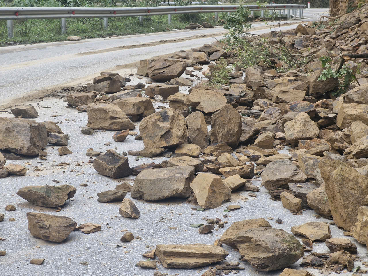 Nhiều khối lượng đất, đá đổ xuống đường. Nhiều khối lượng đất, đá đổ xuống đường.