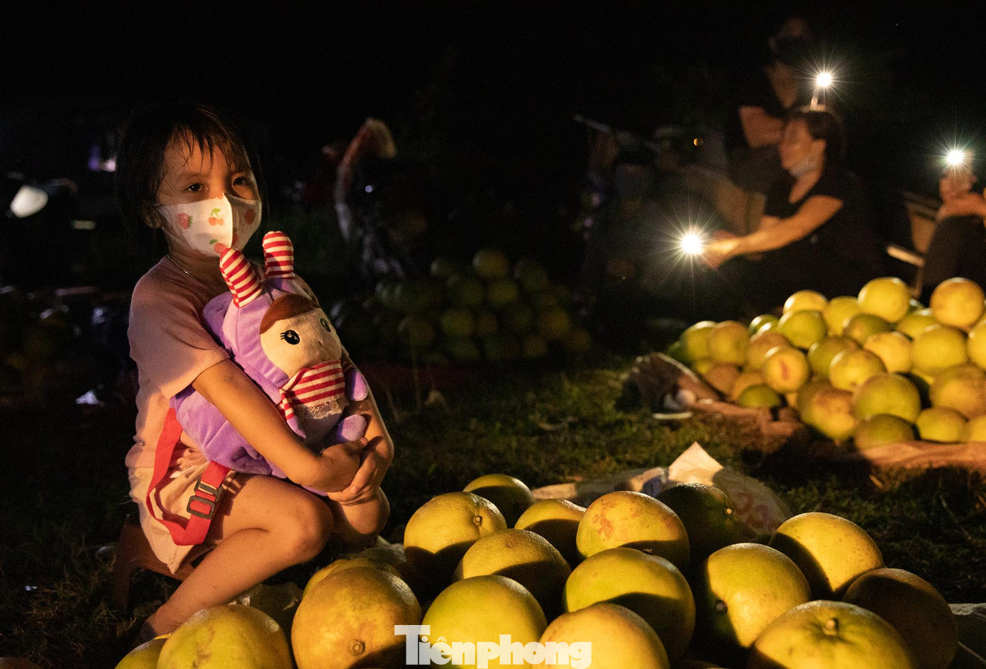 Nhiều đứa trẻ cũng theo mẹ ra chợ để bán bưởi vào buổi đêm.