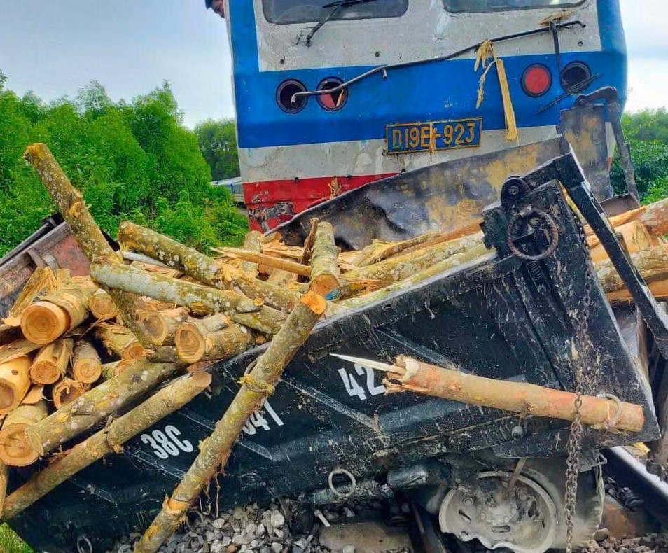 Chiếc xe tải bị tàu hoả đâm hư hỏng nặng, gỗ keo rơi vung vãi giữa đường ray.