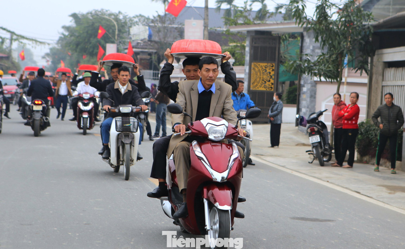 Vì đường từ thôn đến đền thờ cách khoảng 2 km nên người dân thôn Sơn Phú sử dụng xe máy để di chuyển. Những phụ nữ đội lễ vật bánh chưng khoác trên mình chiếc áo dài truyền thống, còn nam giới mặc áo sơ mi và vest.