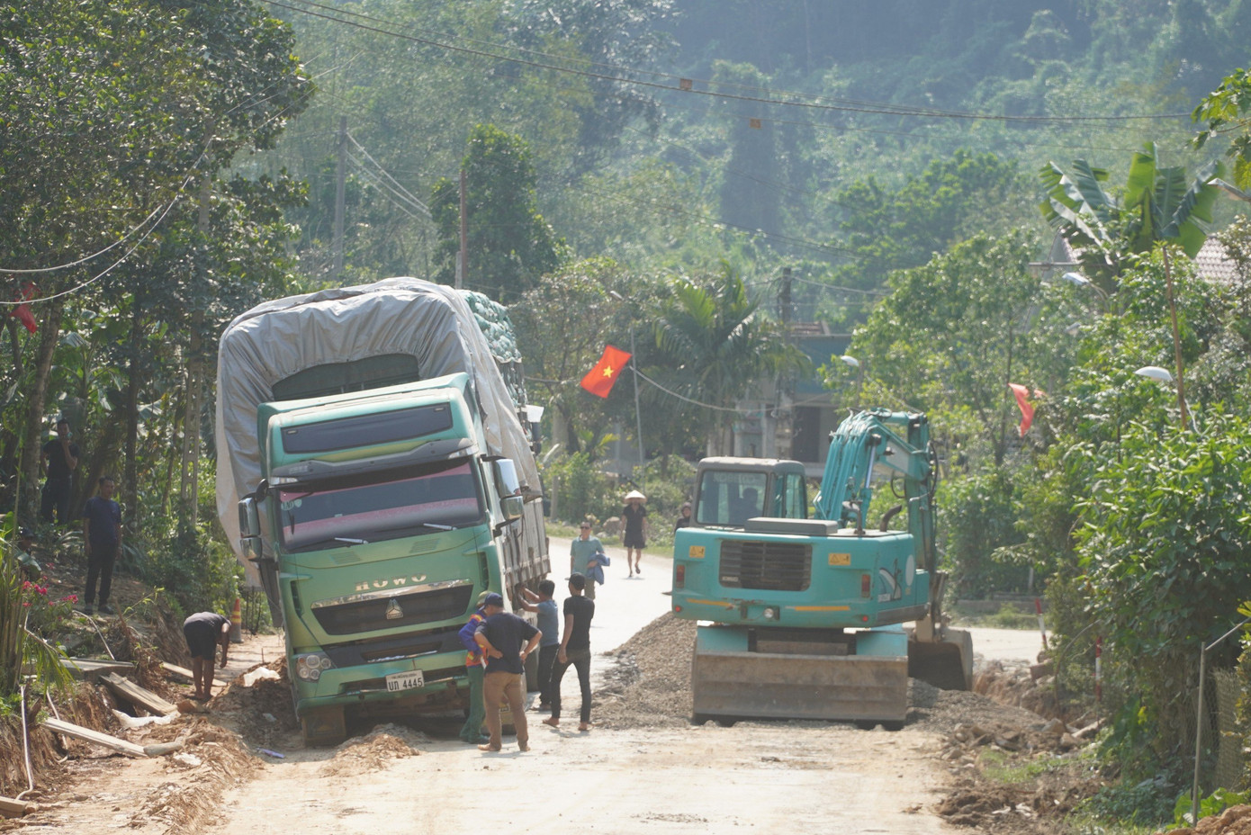Chiếc xe tải bị lún nghiêng không thể di chuyển khiến hàng loạt phương tiện nối đuôi chờ di chuyển.