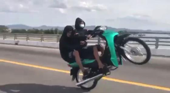 Hai thiếu niên ngồi trên xe bốc đầu khi đang di chuyển trên đường (ảnh cắt từ clip)
