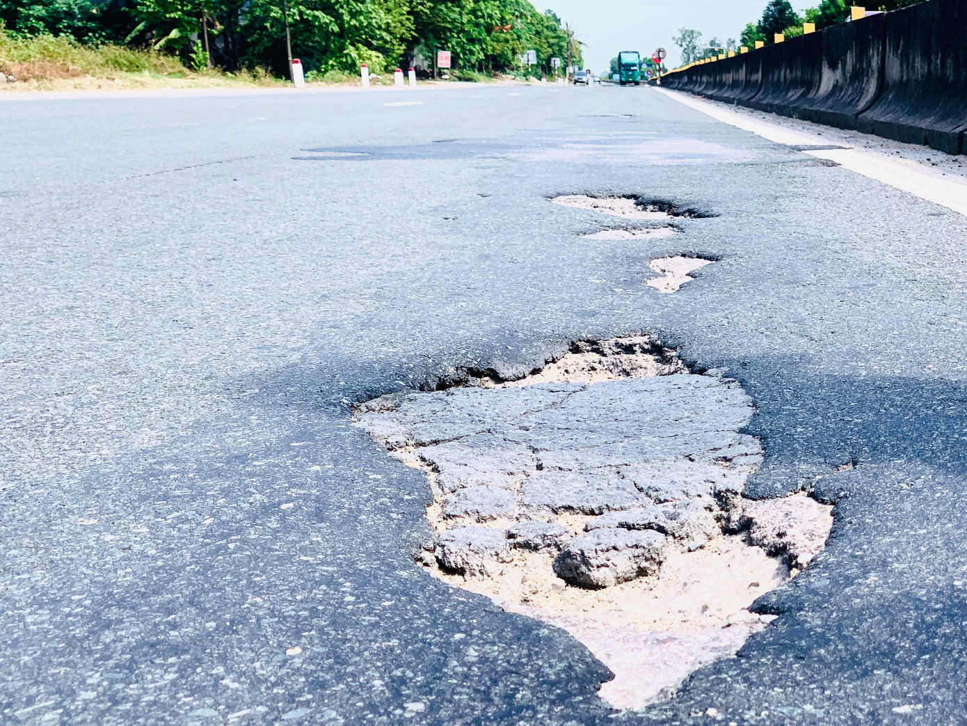 Một số điểm xuất hiện ổ gà, mặt đường bong tróc thành từng mảng. Một số điểm xuất hiện ổ gà, mặt đường bong tróc thành từng mảng.