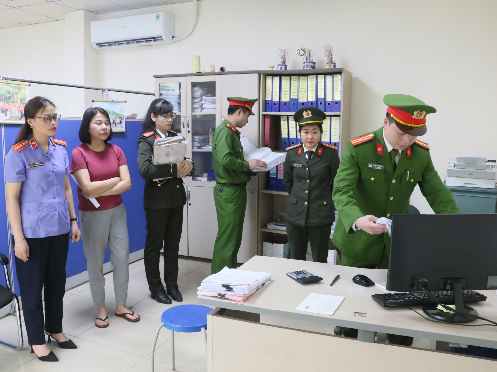 Công an tiến hành khám xét nơi làm việc của các đối tượng. Ảnh: CAHT