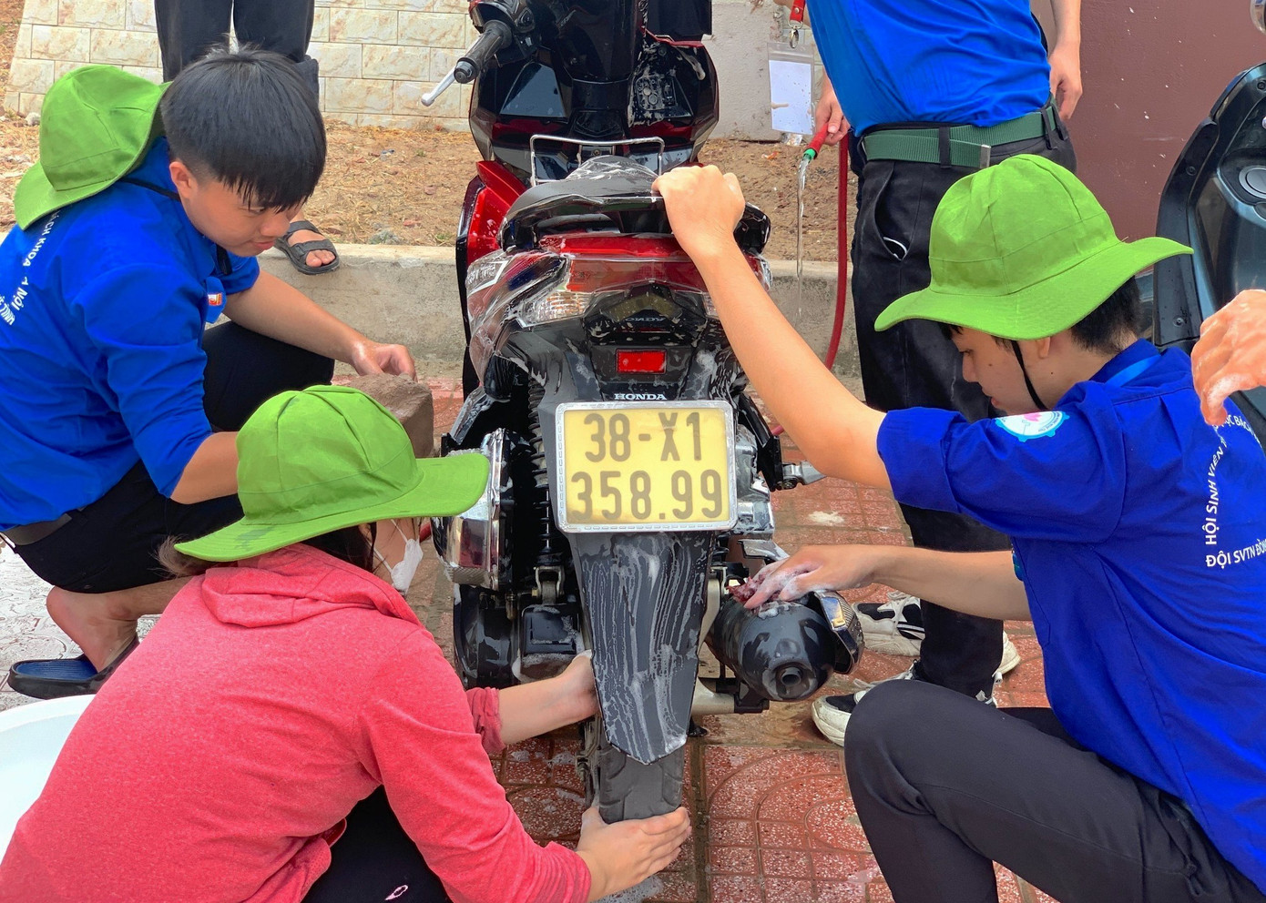 Các bạn sinh viên tình nguyện cùng rửa xe gây quỹ tặng quà cho người nghèo.