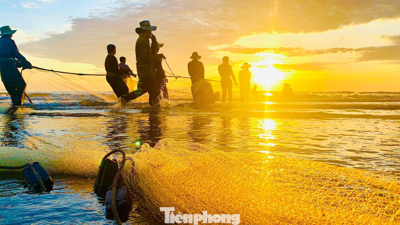 Dọc bờ biển, có hàng chục ngư dân cùng nhau kéo lưới. Lưới được ngư dân buộc cố định ở hai đầu để kéo vào bờ.