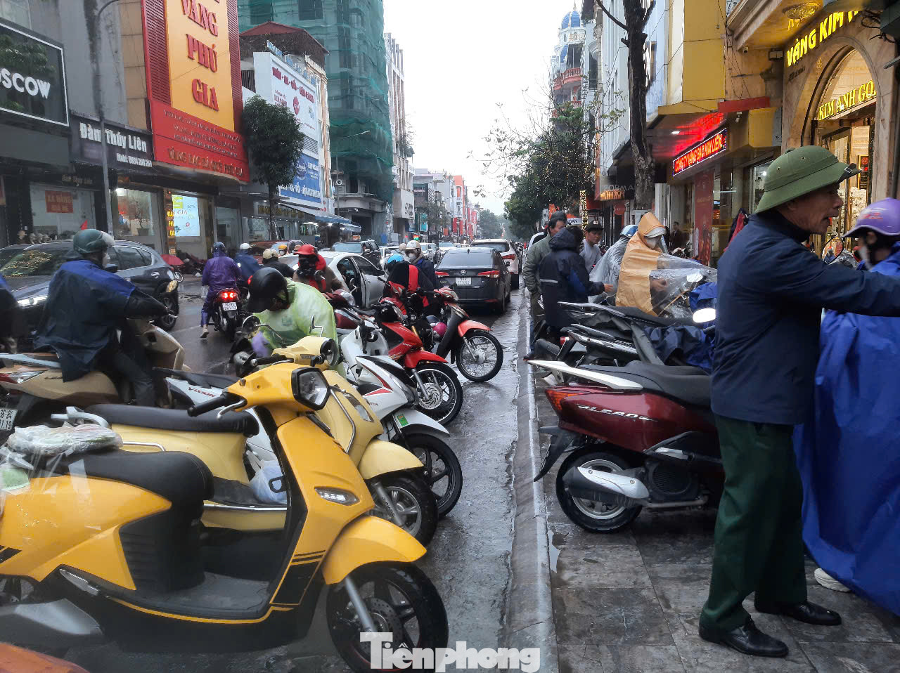 Ghi nhận tại TP. Thanh Hóa, sáng 7/2, do có mưa nên nhiều người đội ô, mang áo mưa đến mua vàng. Song có những cửa hàng kinh doanh vàng thì đông khách, nơi vắng vẻ. Trong ảnh tại cửa hàng vàng Kim Chung (ở 219 đường Lê Hoàn) từ 7h sáng có rất đông người dân đến mua vàng, nhiều phương tiện xe máy của khách hàng phải để xuống lòng đường.