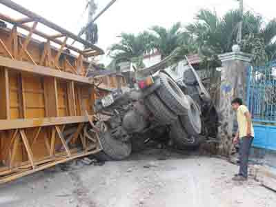 Chiếc xe lật trước khi tông vào nhà dân