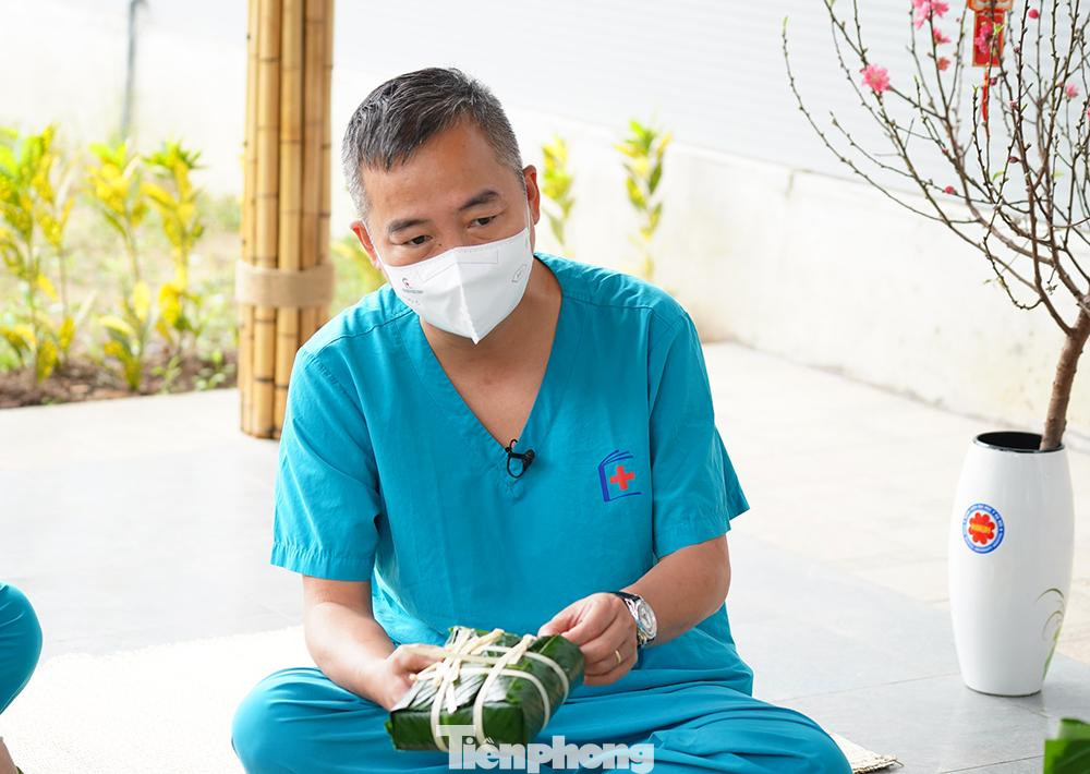 Bác sĩ Nguyễn Lân Hiếu, giám đốc Bệnh viện dã chiến tuyến cuối điều trị COVID-19, vừa gói bánh chưng vừa hỏi thăm các y bác sĩ. Đối với nhiều người, năm nay sẽ là năm đầu tiên đón Tết xa nhà. Đặc biệt là những đoàn công tác của các tỉnh đang hỗ trợ, học tập tại bệnh viện. "Đoàn công tác tỉnh Thanh Hóa, tỉnh Hà Giang đang có mặt tại bệnh viện, anh em sẽ không về quê đón Tết. Chúng tôi tổ chức gói bánh chưng để những anh em đón Tết xa nhà cảm nhận được không khí Tết, động viên tinh thần anh em", bác sĩ Hiếu nói.