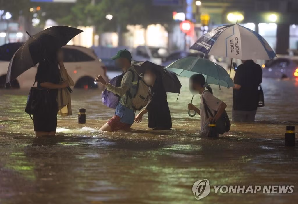 Người dân Seoul lội nước sau cơn mưa lớn tối 8/8. Ảnh: Yonhap