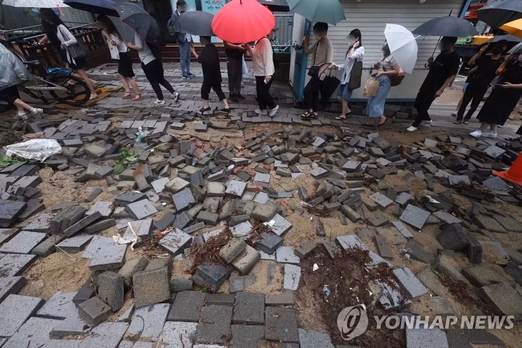 Một con phố bong gạch lát sau mưa lớn ở Seoul. Ảnh: Yonhap
