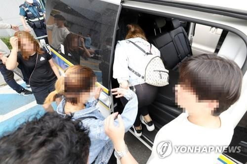 Một nhóm người Việt Nam bị tình nghi đánh bạc được đưa lên xe cảnh sát ở thành phố Gwangju ngày 11/6. Ảnh: Yonhap