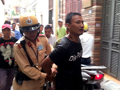 Dũng bị người dân và cảnh sát giao thông quật ngã, sau khi ở trong bụi rậm chạy ra. Ảnh: Phương Sơn