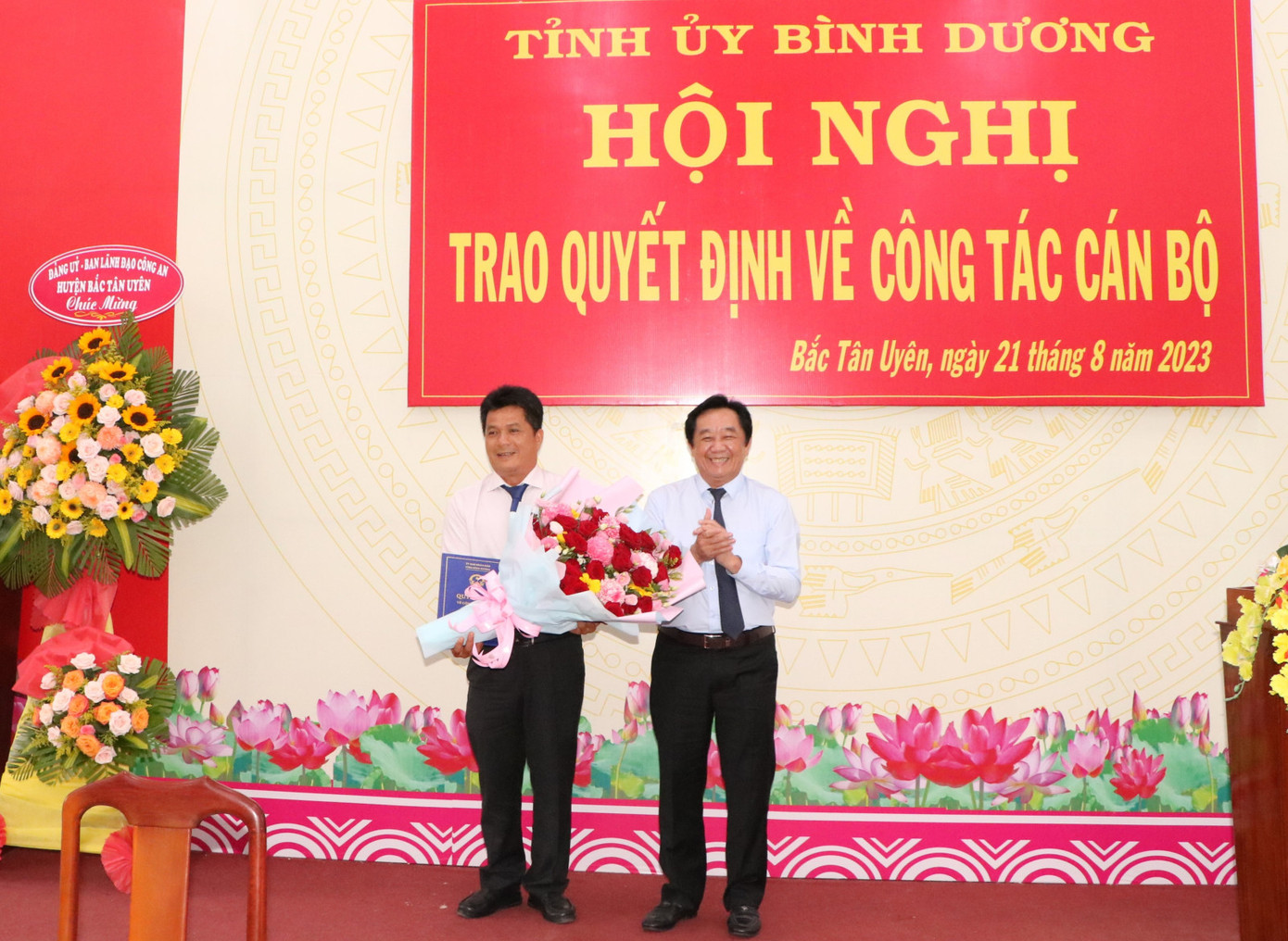 Trao quyết định và tặng hoa chúc mừng ông Nguyễn Thành Thường. Ảnh: Báo Bình Dương.