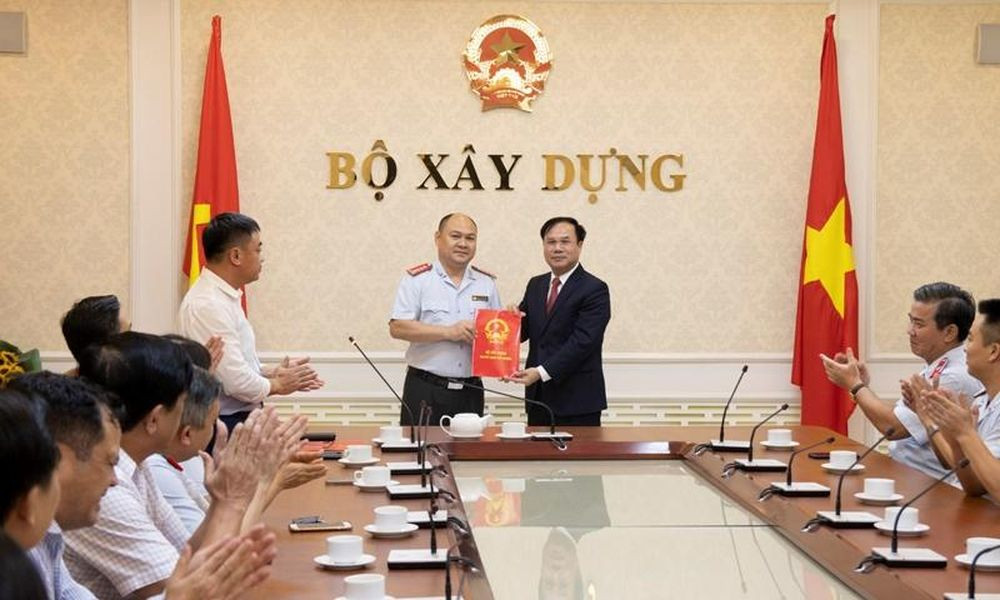 Thứ trưởng Nguyễn Văn Sinh trao Quyết định của Bộ trưởng Bộ Xây dựng bổ nhiệm ông Đinh Quang Tuấn giữ chức vụ Phó Chánh Thanh tra Bộ Xây dựng. Ảnh: Báo Chính phủ