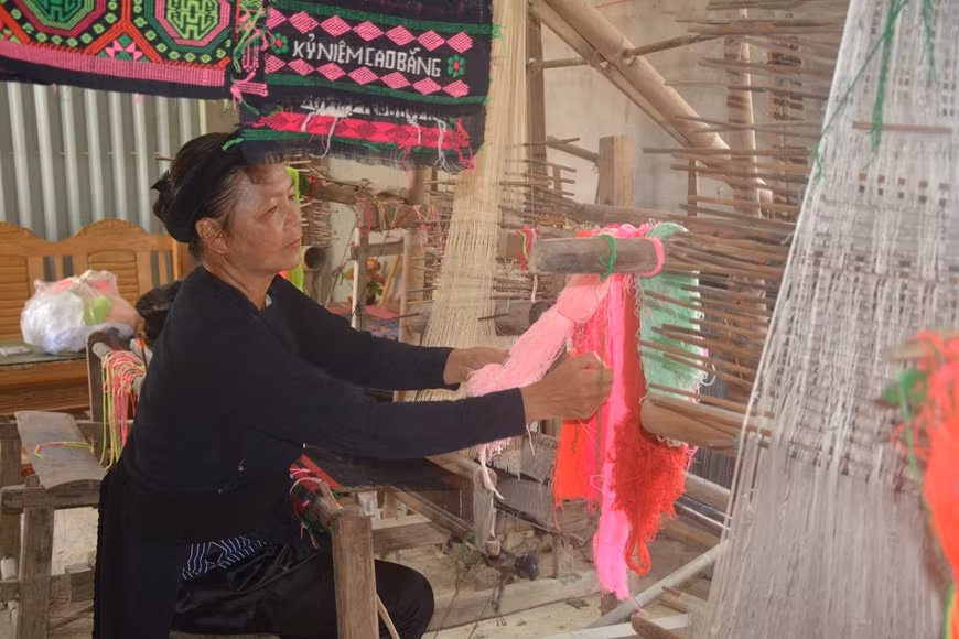 Nghệ nhân Nông Thị Thược bên khung cửi. Ảnh: QĐND