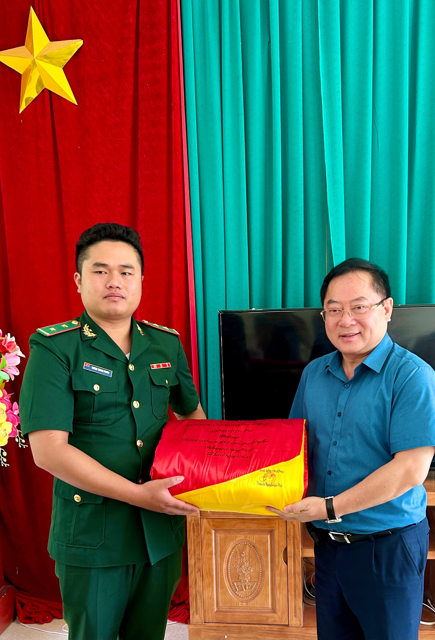 Đại diện Đồn Biên phòng Lũng Cú trao cho báo Tiền Phong lá cờ 54 m2 đã treo trên Cột cờ Lũng Cú. Ảnh Phạm Duy