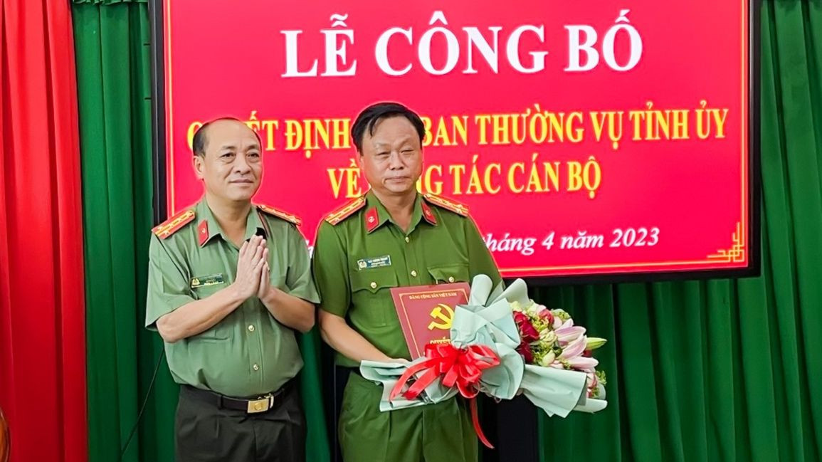Đại tá Nguyễn Trọng Dũng - Giám đốc Công an tỉnh Vĩnh Long trao quyết định và tặng hoa chúc mừng Đại tá Trà Quang Thanh. Ảnh: T.T
