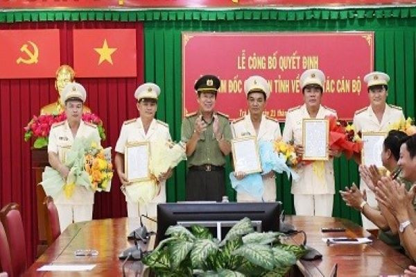 Đại tá Huỳnh Văn Thình - Phó Giám đốc Công an tỉnh Trà Vinh trao quyết định và chúc mừng các cán bộ được điều động. Ảnh: H.Giang
