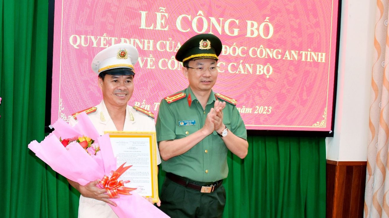 Đại tá Trương Sơn Lâm - Giám đốc Công an tỉnh Bến Tre trao quyết định và tặng hoa chúc mừng Đại tá Lê Văn Hiền. Ảnh: Cổng thông tin điện tử Công an tỉnh Bến Tre.