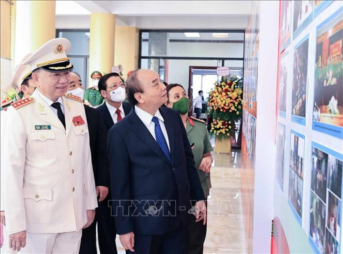 Chủ tịch nước Nguyễn Xuân Phúc tham quan trưng bày ảnh về các hoạt động của lực lượng An ninh nhân dân. Ảnh: Thống Nhất/TTXVN.