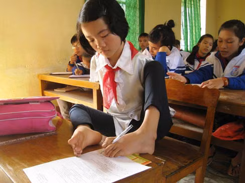 Để việc học chữ của con gái được thuận tiện, người cha đã sáng chế ra một chiếc bàn phù hợp với thân hình nhỏ bé của em. Ảnh: Lê Hoàng. Để việc học chữ của con gái được thuận tiện, người cha đã sáng chế ra một chiếc bàn phù hợp với thân hình nhỏ bé của em.