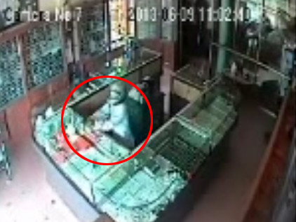 Ảnh chụp từ clip ghi lại cảnh đối tượng dùng súng chống trả và đập tủ kính, cướp vàng. Ảnh chụp từ clip ghi lại cảnh đối tượng dùng súng chống trả và đập tủ kính, cướp vàng