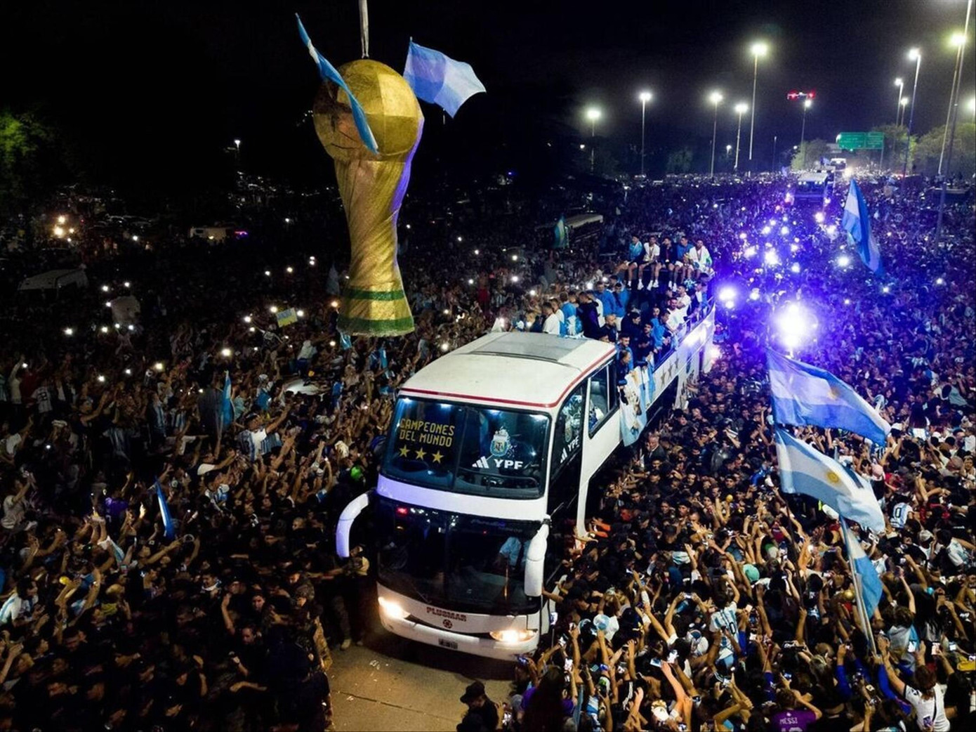 Người hâm mộ vây quanh chiếc xe bus chở ĐT Argentina. Ảnh: IE