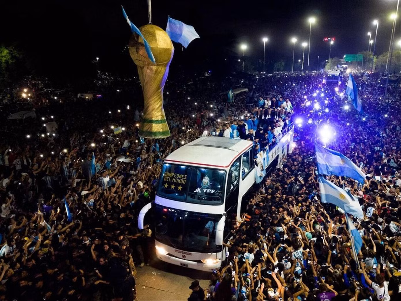 Người hâm mộ vây quanh chiếc xe bus chở ĐT Argentina. Ảnh: IE