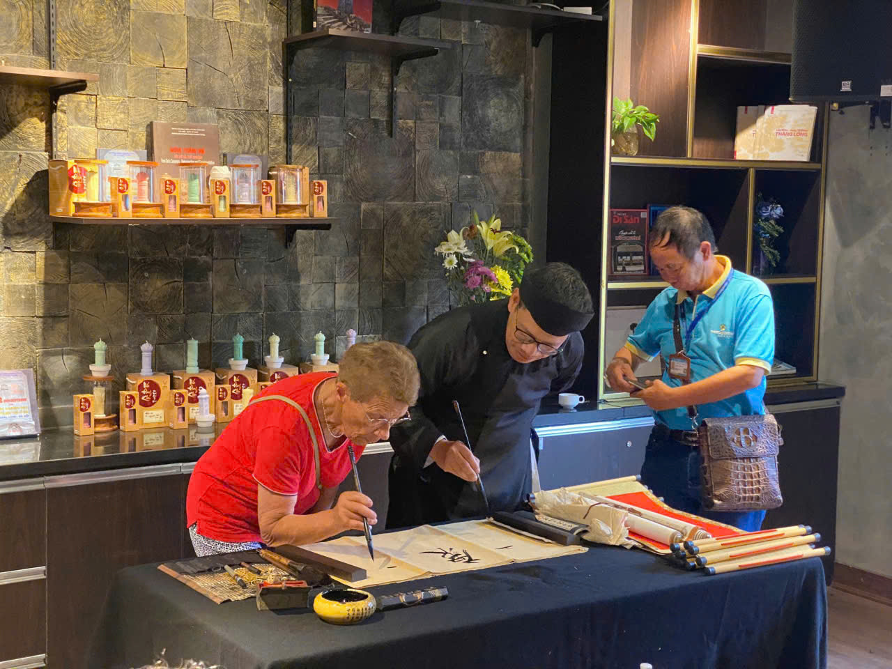 Thư pháp gia gần 30 năm cho chữ ở Văn Miếu Nguyễn Văn Nguyên đang dạy khách Tây viết chữ. Ảnh: Nguyễn Văn Nguyên cung cấp