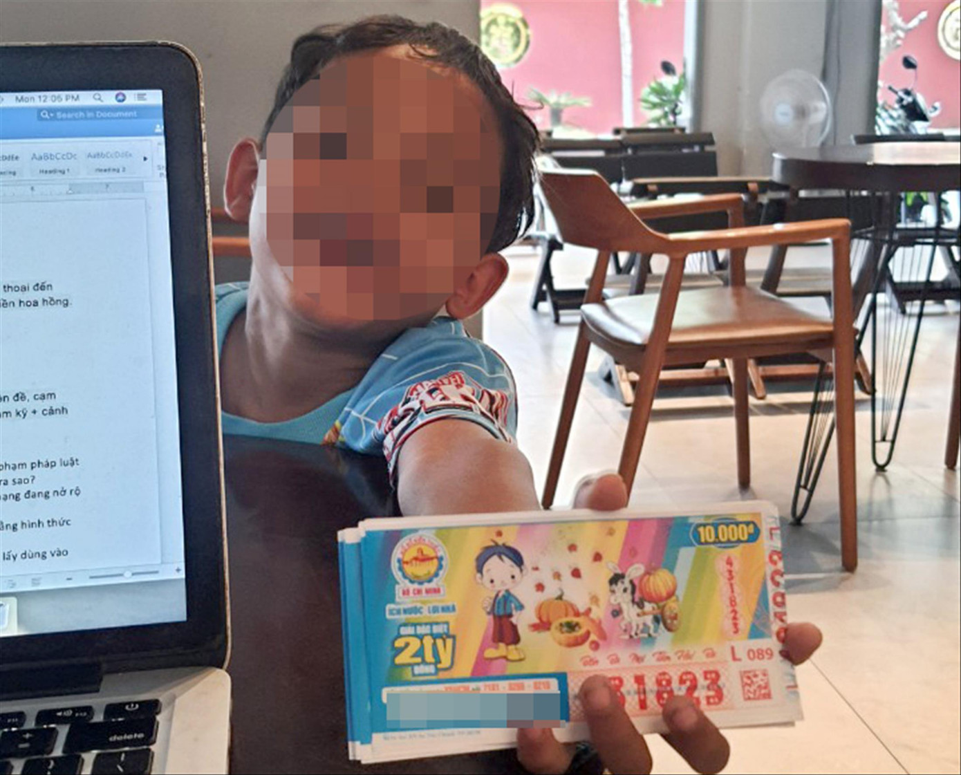 Một bé trai mời khách mua vé số trong quán cà phê ở quận 6. Ảnh: Hoàng Thuận