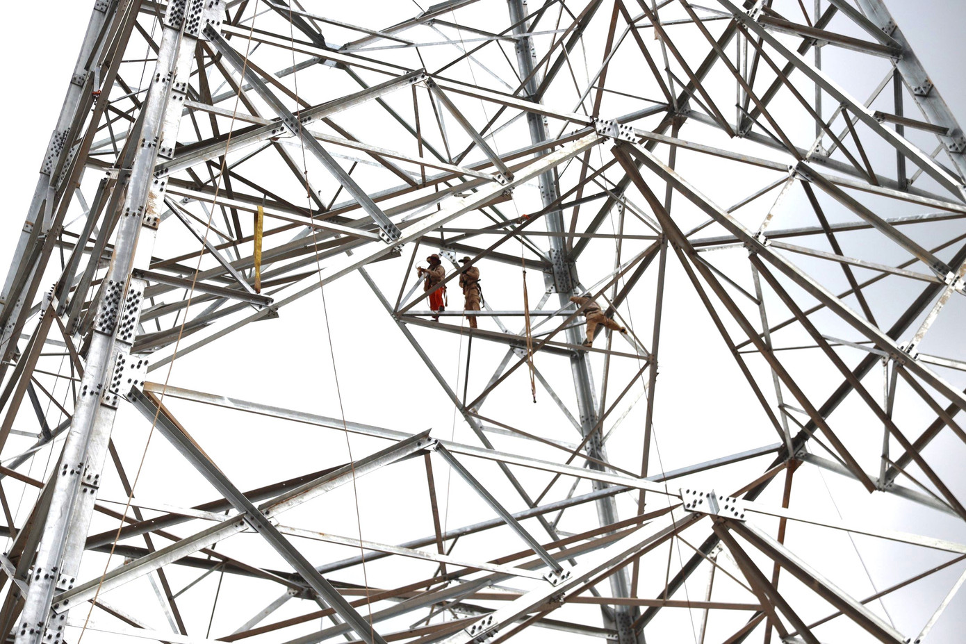 Công nhân căng mình giữa nắng nóng lắp đặt từng cấu kiện cột 329. Ảnh: Cảnh Huệ