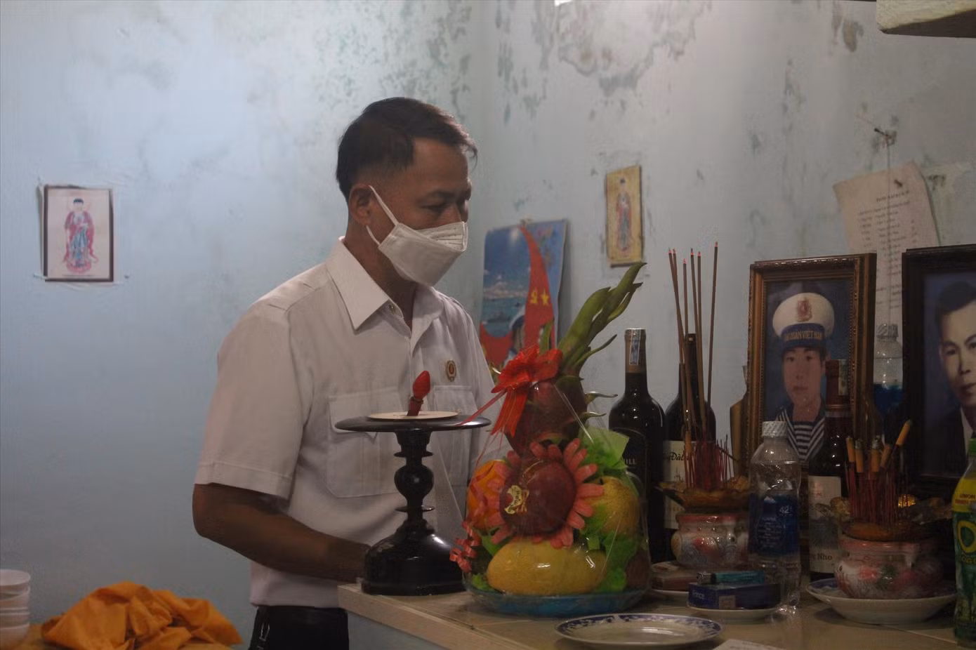 Đồng đội thủ thỉ bên tấm di ảnh của liệt sĩ Nguyễn Hữu Lộc, “mời” đồng đội về dự lễ tưởng niệm ngày giỗ chung của 64 liệt sĩ Gạc Ma. Ảnh: Giang Thanh