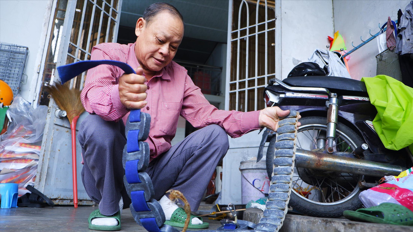 Ông Lịch bên chiếc đai chì nặng gần 20kg dùng để lặn dưới đáy sông Hàn. Ảnh: Nguyễn Thành Ông Lịch bên chiếc đai chì nặng gần 20kg dùng để lặn dưới đáy sông Hàn. Ảnh: Nguyễn Thành