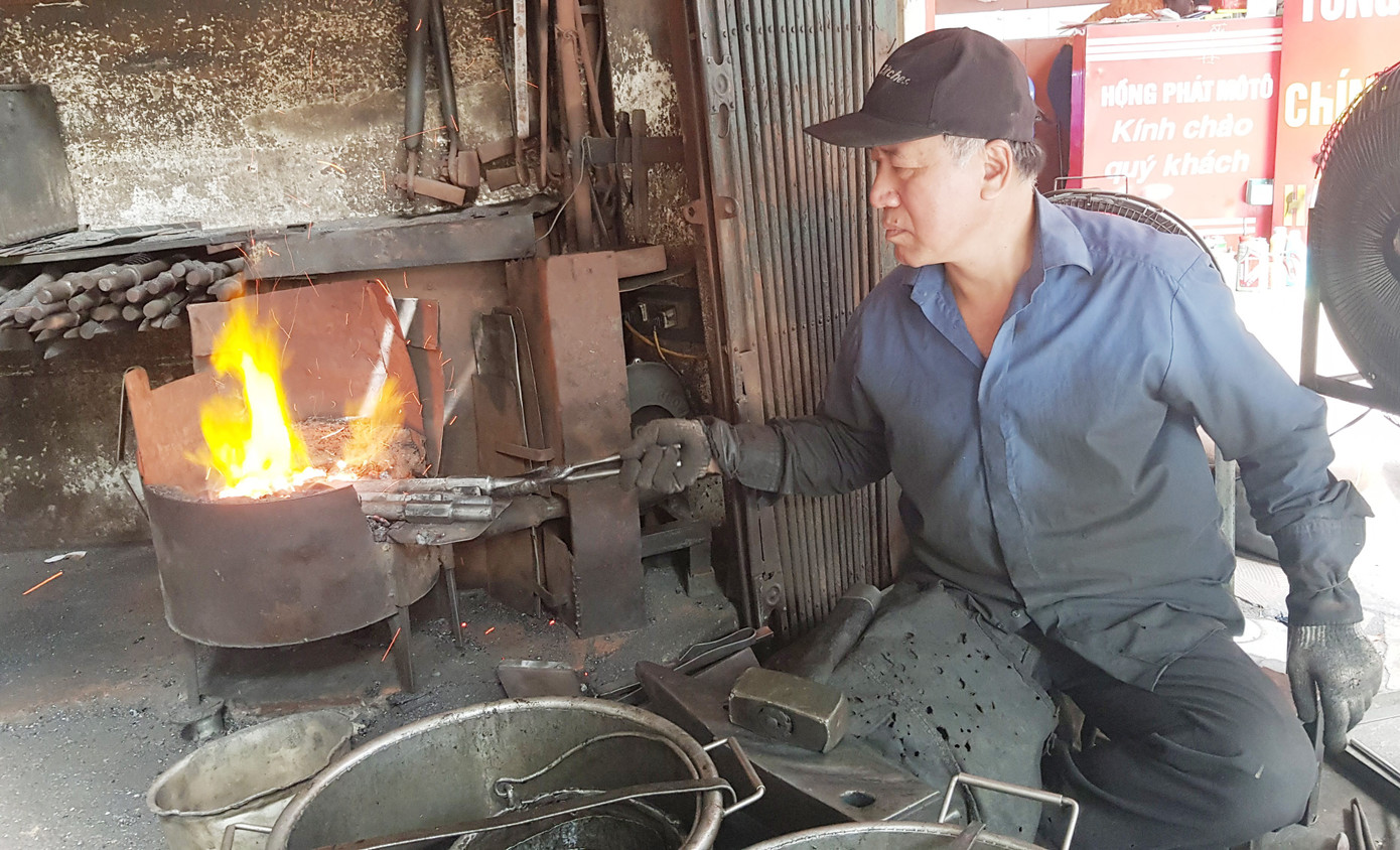 Ông Nguyễn Phương Hùng đang nung những chiếc đục trong lò. Ảnh: KIẾN NGHĨA