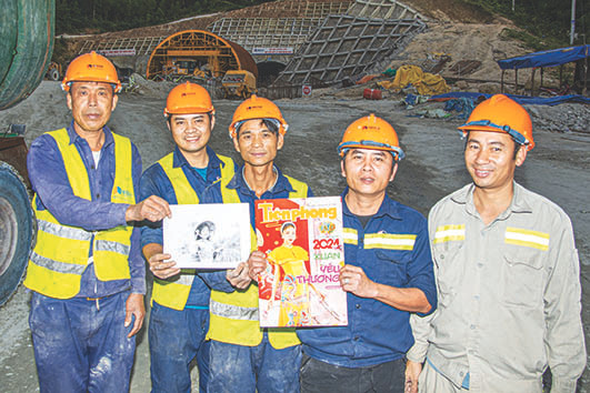 Công nhân tươi cười với tấm ảnh chị Trâm trước cửa hầm số 2. Ảnh: Văn Chương Công nhân tươi cười với tấm ảnh chị Trâm trước cửa hầm số 2. Ảnh: Văn Chương