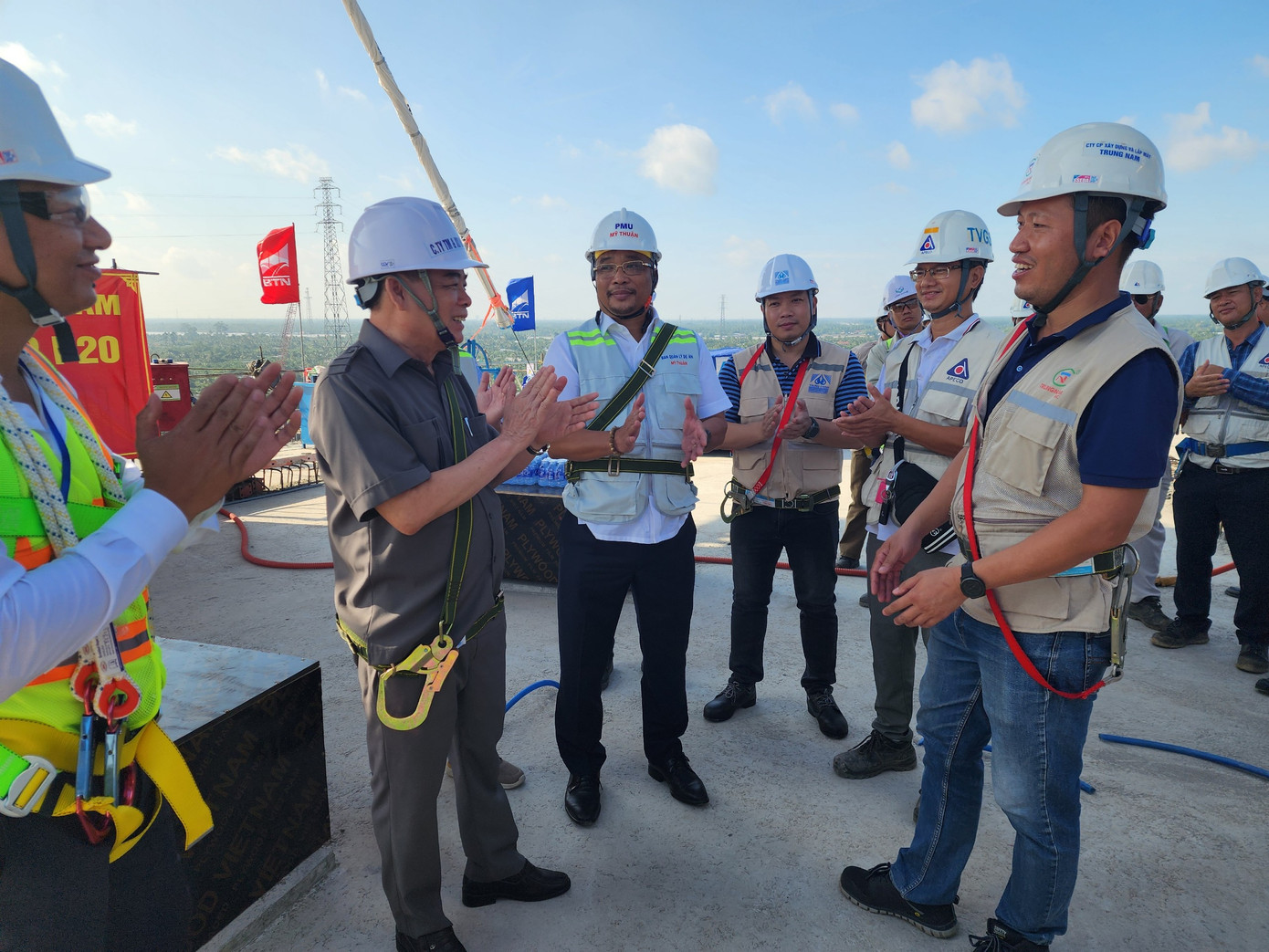 Chủ tịch UBND tỉnh Bến Tre Trần Ngọc Tam (áo sẫm màu) trò chuyện với cán bộ, kỹ sư tại sự kiện căng bó cáp đầu tiên của dự án cầu Rạch Miễu 2