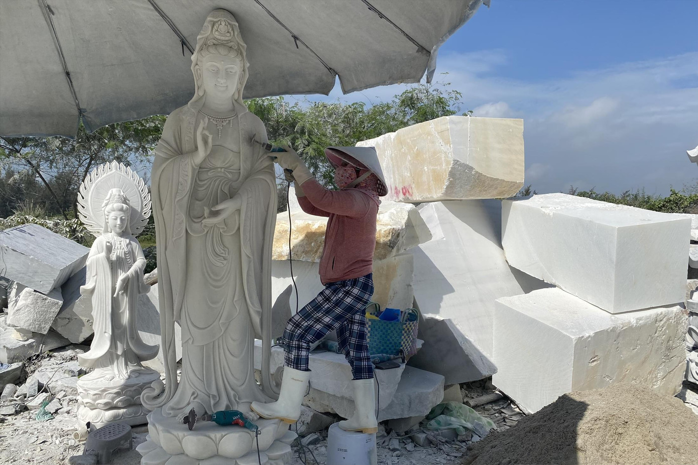 Bà Huỳnh Thị Mười đang hoàn thiện bức tượng Phật. Ảnh: Minh Hiền