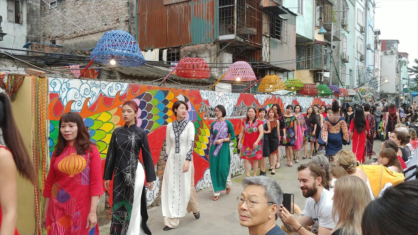Người dân tham gia trình diễn thời trang áo dài của NTK Diego Cortizas tại không gian nghệ thuật Phúc Tân. Ảnh: THẾ SƠN