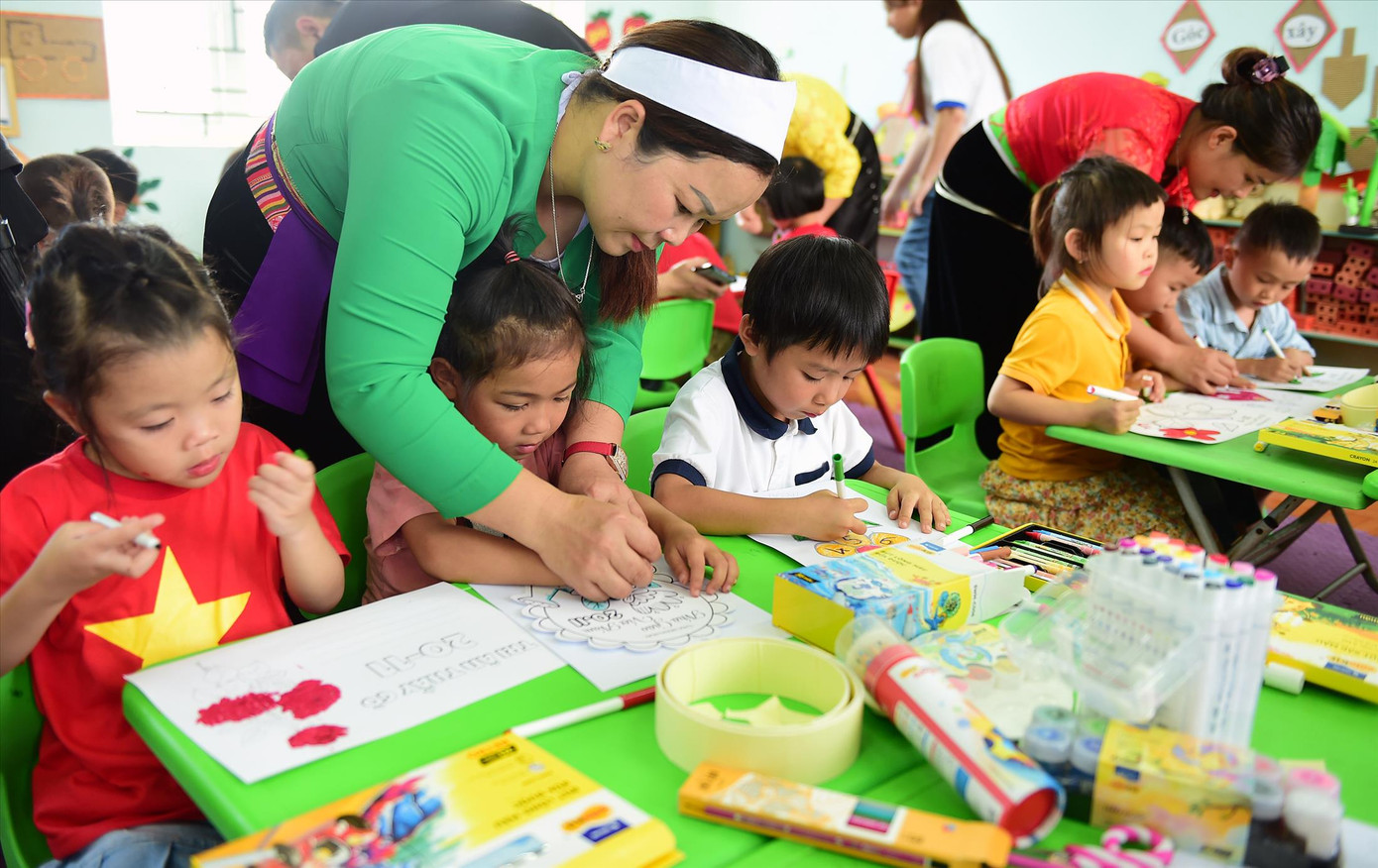 Cô Quách Thị Bích Nụ hướng dẫn các em học sinh trường mầm non Yên Hòa vẽ tranh, làm thiệp trong buổi hoạt động lớp học sáng tạo. Ảnh: Xuân Tùng