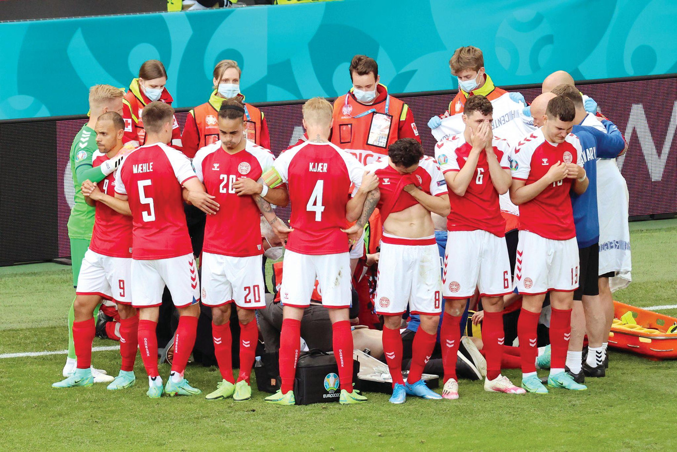 Các cầu thủ Đan Mạch tạo thành hàng rào để bảo vệ sự riêng tư cho người đồng đội Eriksen. Ảnh: Reuters Các cầu thủ Đan Mạch tạo thành hàng rào để bảo vệ sự riêng tư cho người đồng đội Eriksen. Ảnh: Reuters