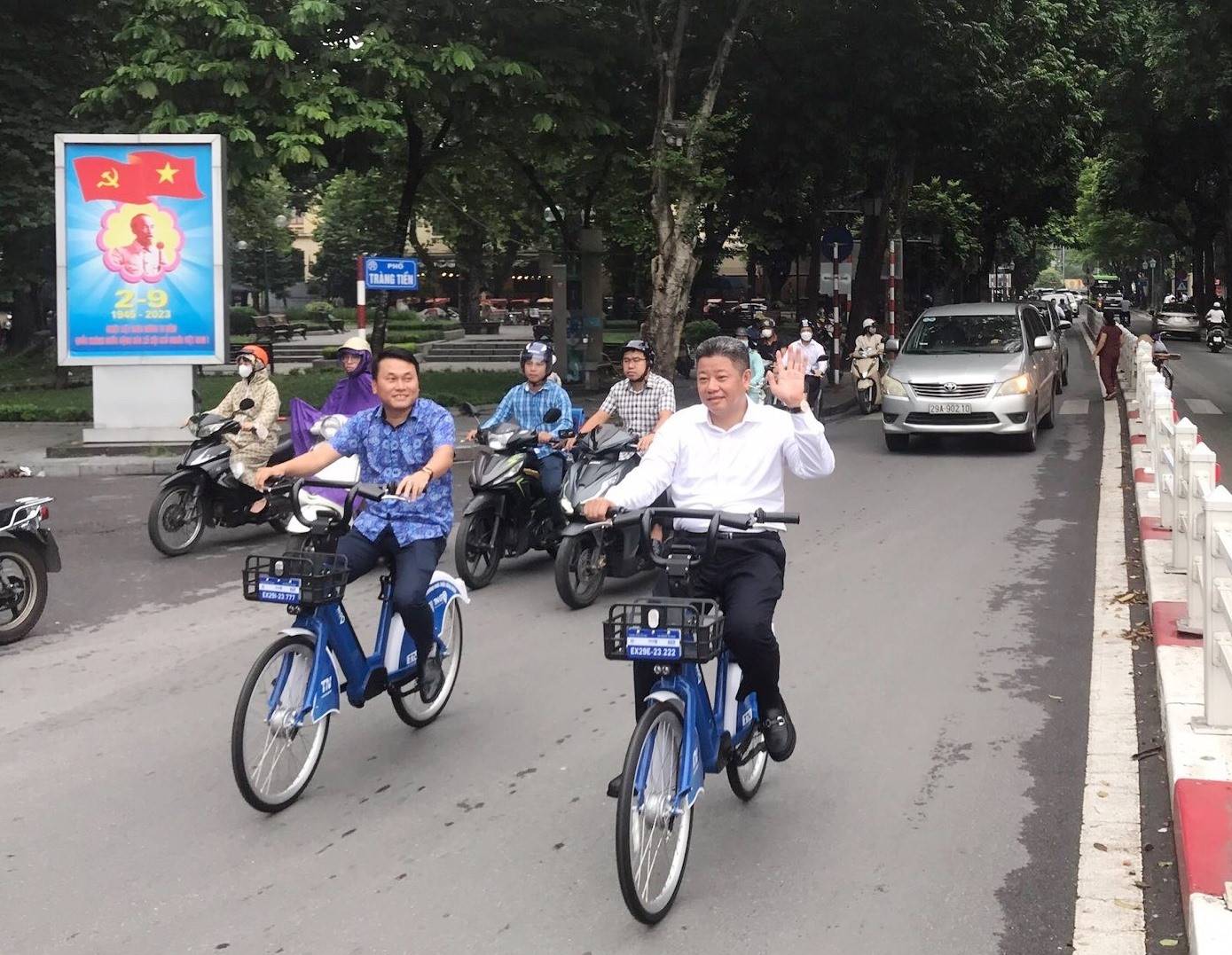 Phó Chủ tịch UBND TP Hà Nội Nguyễn Mạnh Quyền (người vẫy tay chào) và Chủ tịch HĐQT Cty CP Tập đoàn Trí Nam Đỗ Bá Dân (đi bên phía trái) trải nghiệm xe đạp công cộng sau lễ khai trương