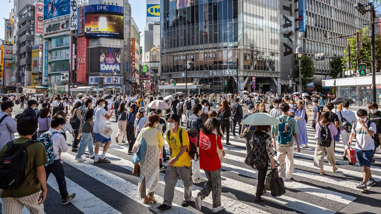 Người dân đi bộ qua Giao lộ Shibuya ở Tokyo Người dân đi bộ qua Giao lộ Shibuya ở Tokyo