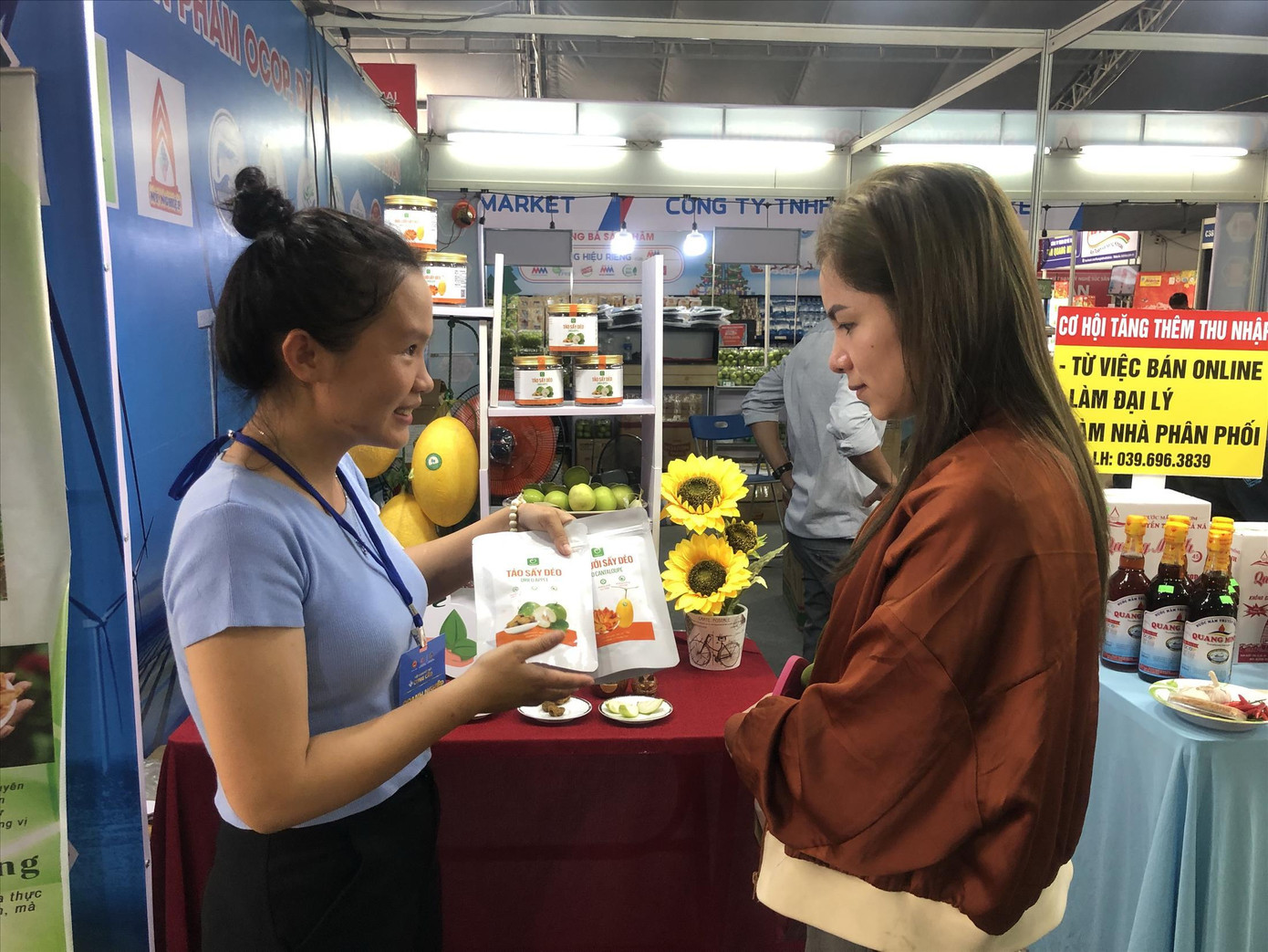 Nữ startup trẻ Nguyễn Thị Kim Oanh (bên trái) giới thiệu táo sấy dẻo cho khách hàng