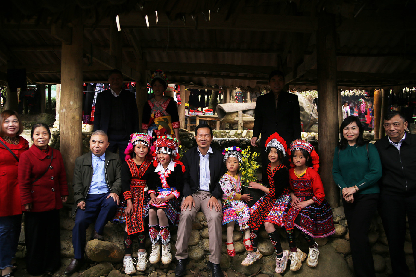 Du khách chụp ảnh kỉ niệm cùng các bé gái người Mông ở chợ phiên Sin Suối Hồ. Ảnh: LỘC LIÊN