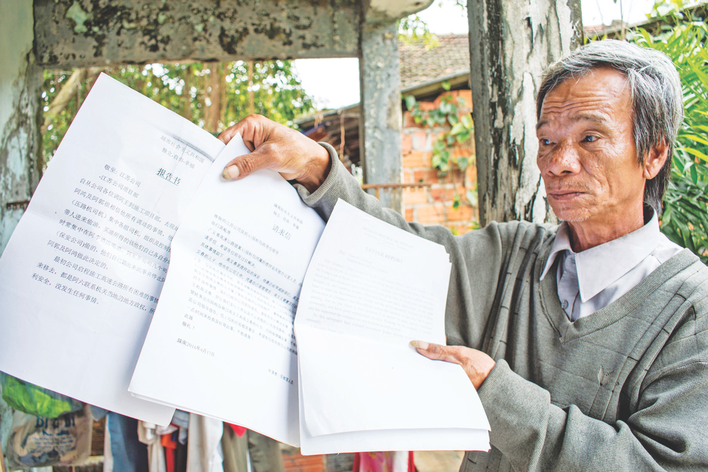 Lão nông Phạm Tấn Lực với xấp đơn tố cáo sai phạm cao tốc Đà Nẵng - Quảng Ngãi viết bằng 2 thứ tiếng Việt Trung. Ảnh: Lê Văn Chương Lão nông Phạm Tấn Lực với xấp đơn tố cáo sai phạm cao tốc Đà Nẵng - Quảng Ngãi viết bằng 2 thứ tiếng Việt Trung. Ảnh: Lê Văn Chương