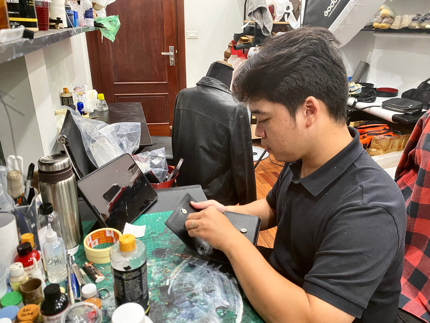 Anh Nguyễn Đức Phi Hùng đang phục chế một chiếc ví của thương hiệu Yves Saint Laurent (Pháp) Anh Nguyễn Đức Phi Hùng đang phục chế một chiếc ví của thương hiệu Yves Saint Laurent (Pháp)