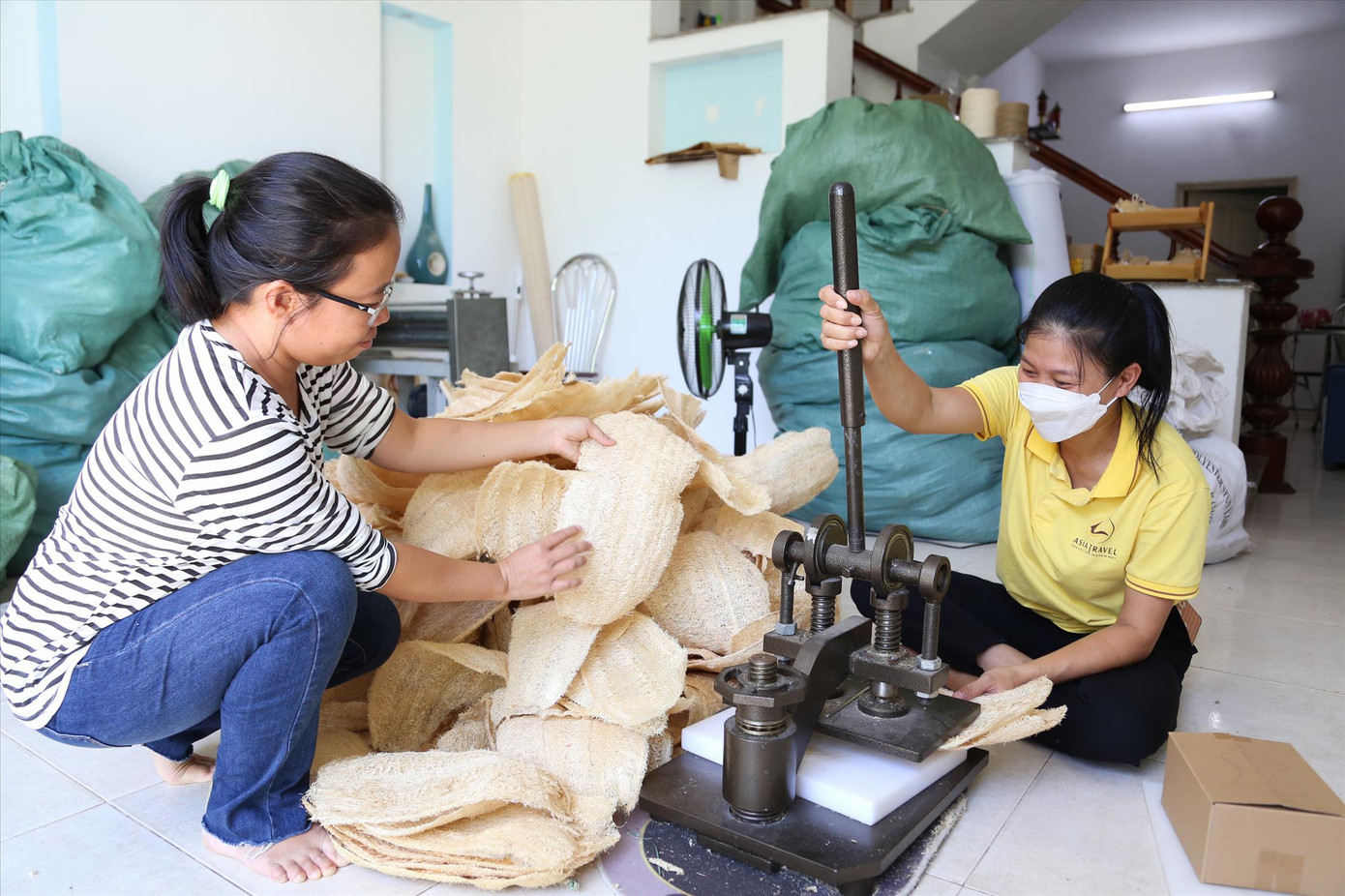 Chị Thư áo kẻ trong xưởng sản xuất sản phẩm từ xơ mướp