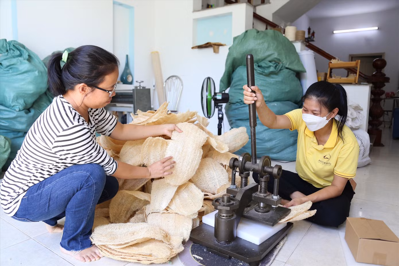 Chị Thư áo kẻ trong xưởng sản xuất sản phẩm từ xơ mướp